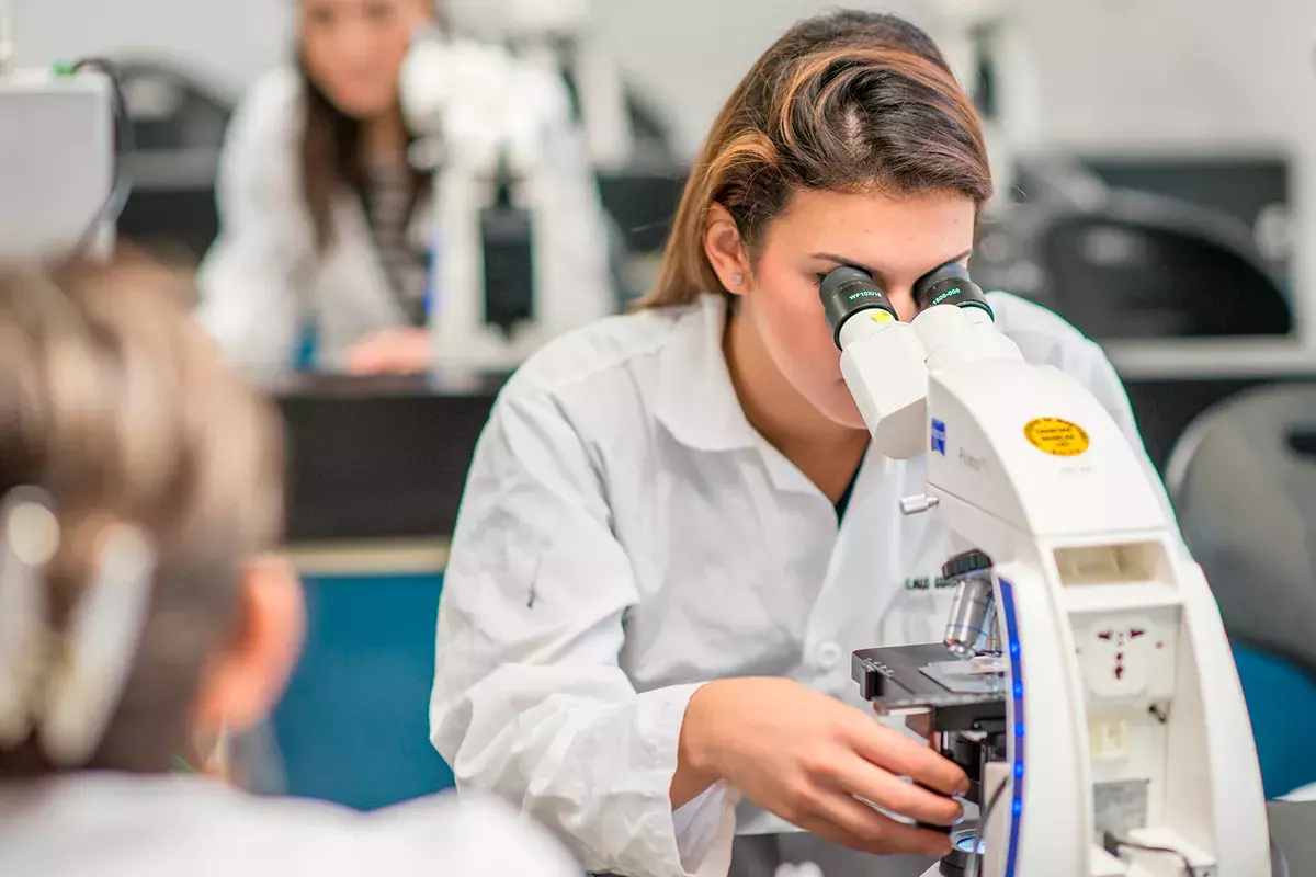 Alumna viendo en el microscopio.