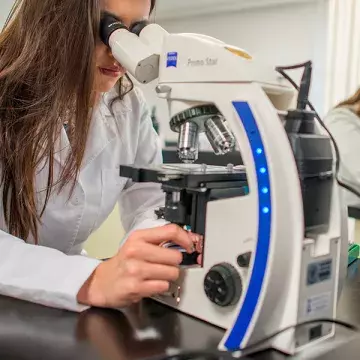 Alumna viendo en el microscopio.