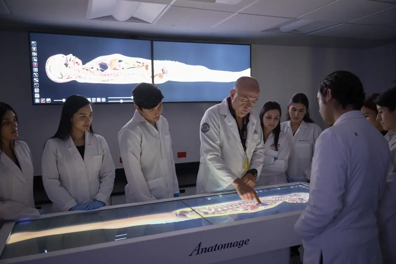 Maestro enseñando a alumnas cuerpo humano.