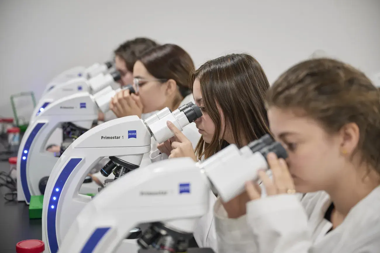 Alumna viendo en el microscopio.